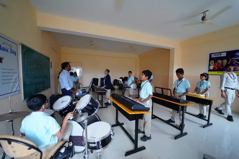 Students learning drums and keyboard in the music room